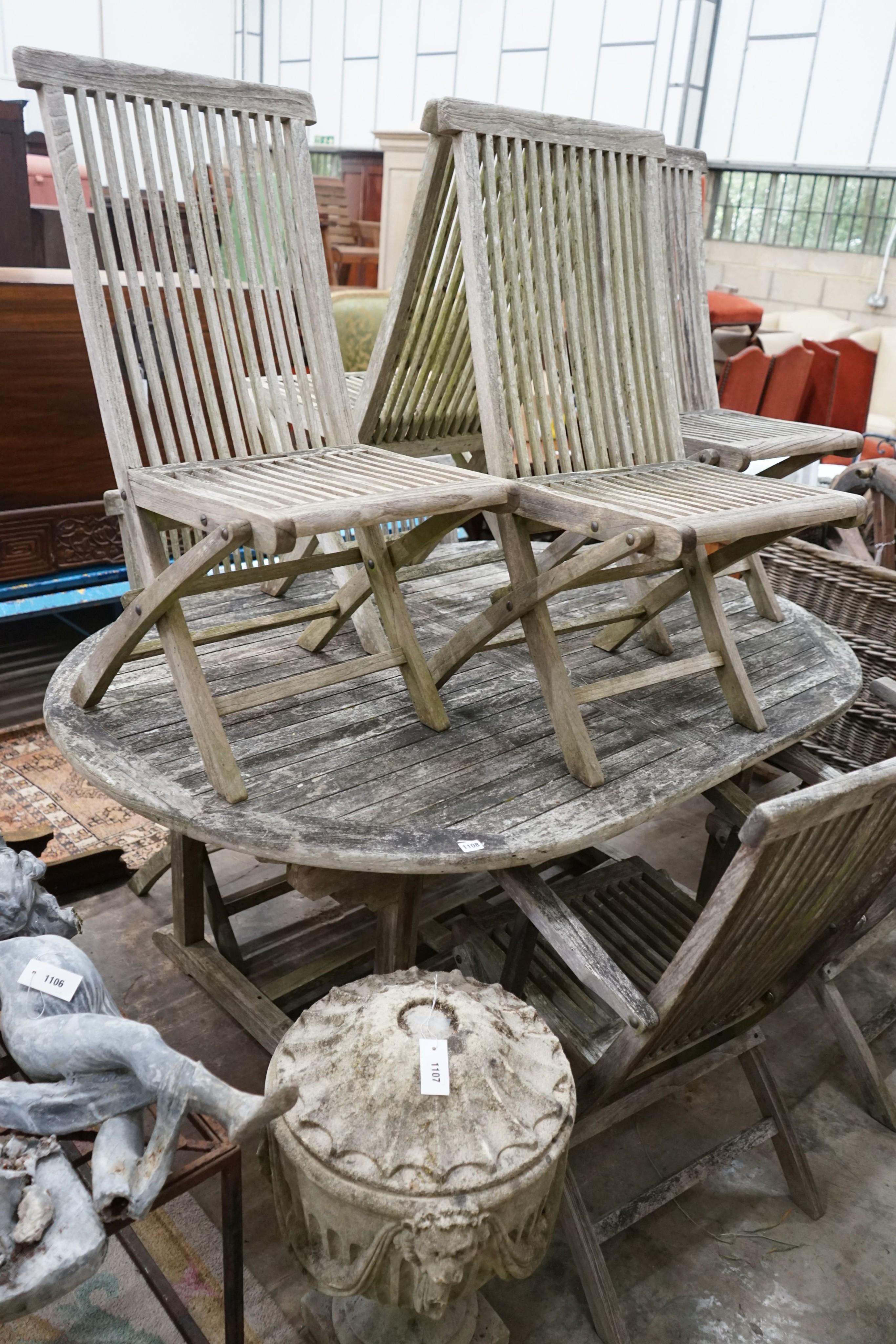 A weathered teak oval garden table, length 178cm, width 120cm, height 77cm and eight folding chairs, two with arms
